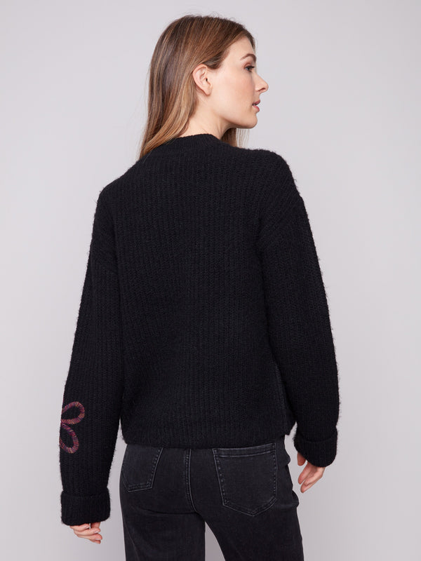 Fashionable black mock neck sweater featuring exquisite floral soutache details for added charm by Charlie B.