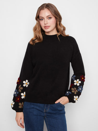 Black sweater featuring long balloon sleeves with floral embroidery, adding a playful touch by Charlie B.