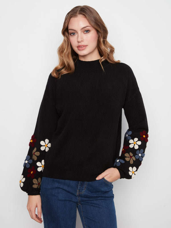 Black sweater featuring long balloon sleeves with floral embroidery, adding a playful touch by Charlie B.