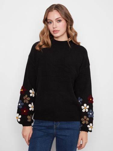 Cozy black sweater designed with beautiful floral patterns on the sleeves and ribbed details for comfort by Charlie B.