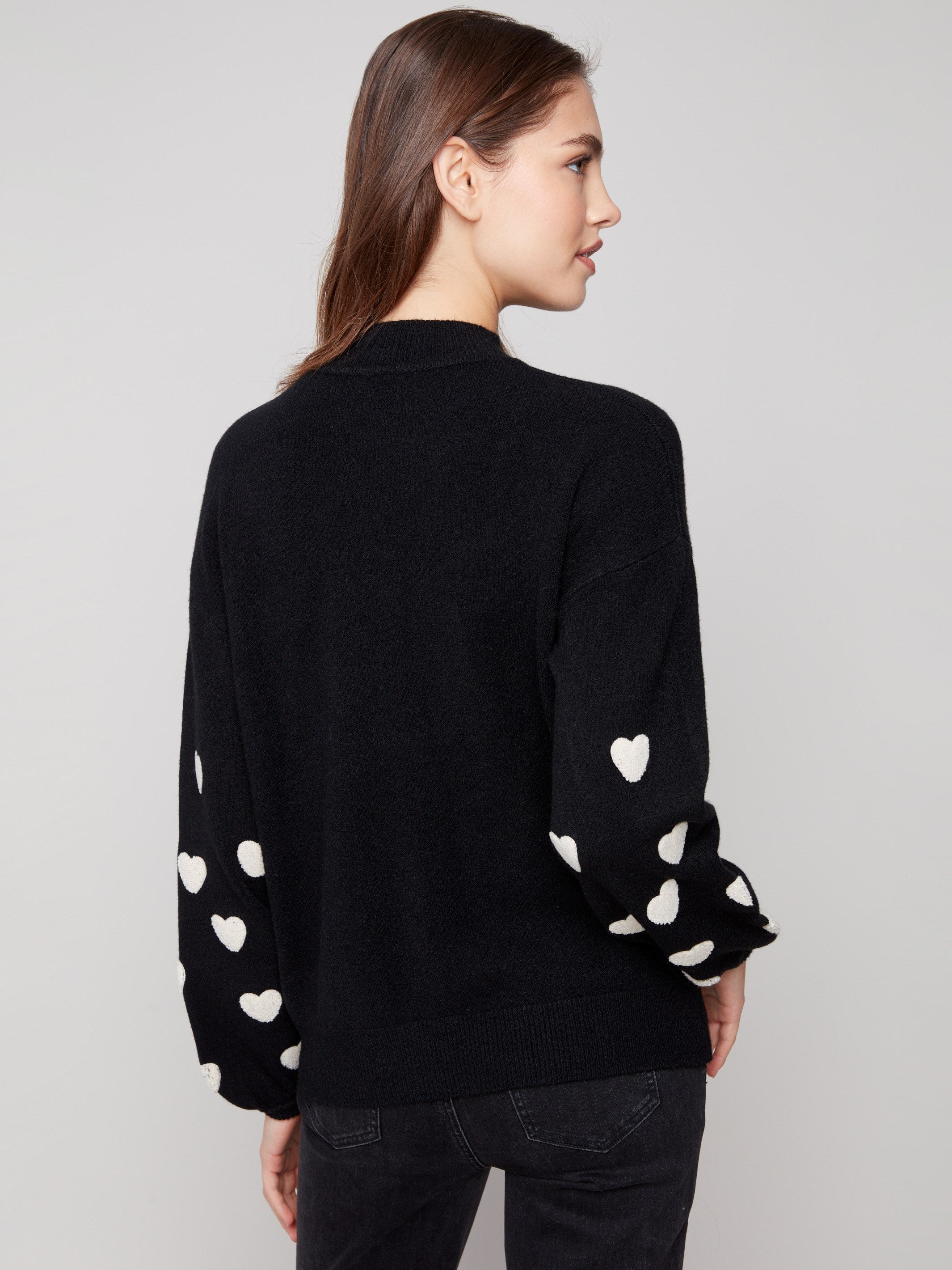 Comfortable and fashionable drop shoulder design in this black sweater, adorned with white hearts by Charlie B.
