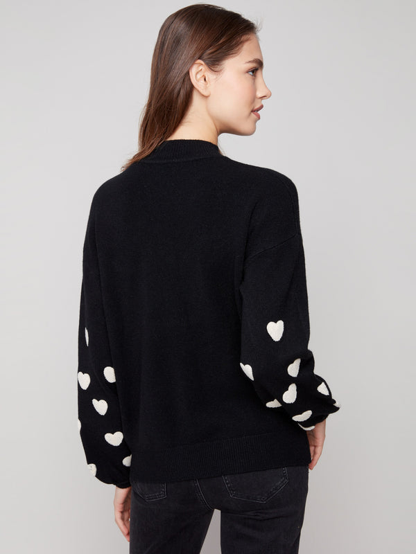 Comfortable and fashionable drop shoulder design in this black sweater, adorned with white hearts by Charlie B.