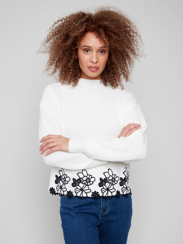 Sweater featuring a mock neck and elegant black floral lace detailing at the hem by Charlie B.