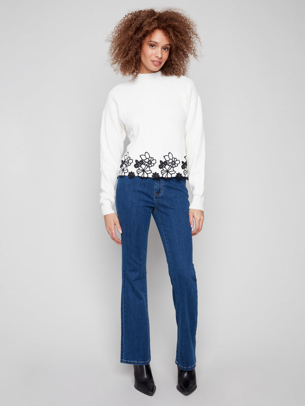 Hip-length ecru sweater with intricate black floral lace hem, ideal for casual elegance by Charlie B.