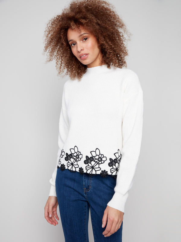 Stylish ecru sweater with mock neck and beautiful floral lace accents at the hemline by Charlie B.