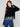 Sophisticated black sweater with a charming floral lace hem and hip-length cut, perfect for versatile styling by Charlie B.
