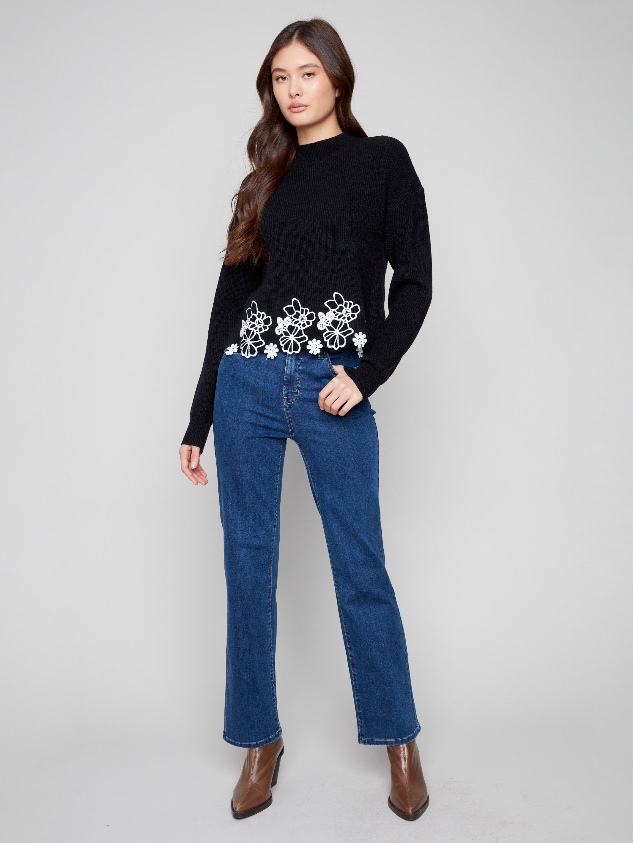 Chic black mock neck sweater with exquisite white floral lace detailing at the hem for a feminine touch by Charlie B.