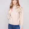 Heather oat sweater with a chic mock neck, showcasing elegant floral embroidery and knit cuffs by Charlie B.