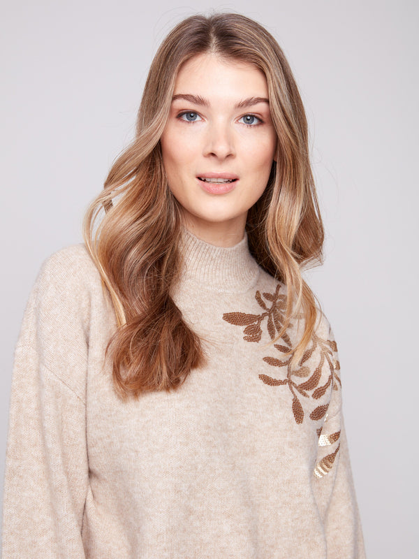 Elegant drop shoulders enhance the heather oat sweater adorned with sequin floral details by Charlie B.
