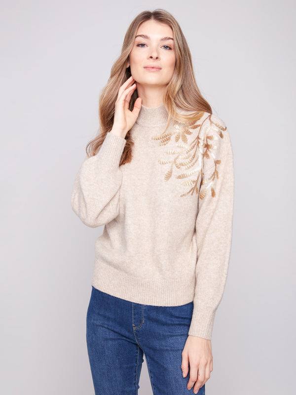 Charming mock neck and delicate embroidery make this heather oat sweater a must-have piece by Charlie B.