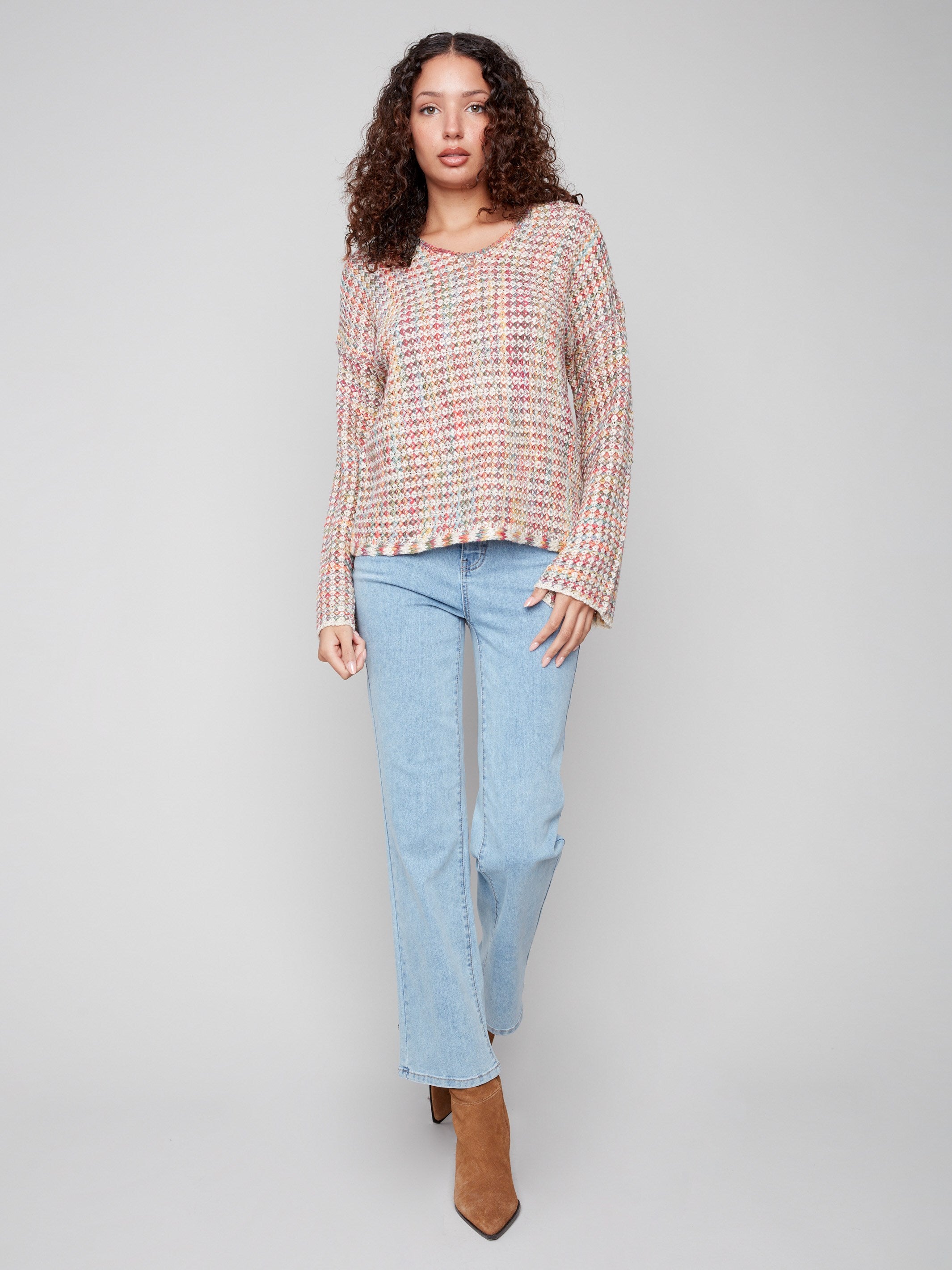 A vibrant crochet sweater with long sleeves, designed with intricate novelty yarn patterns by Charlie B.