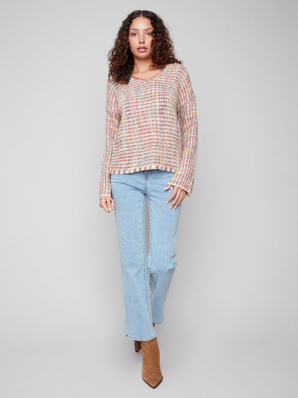 A vibrant crochet sweater with long sleeves, designed with intricate novelty yarn patterns by Charlie B.
