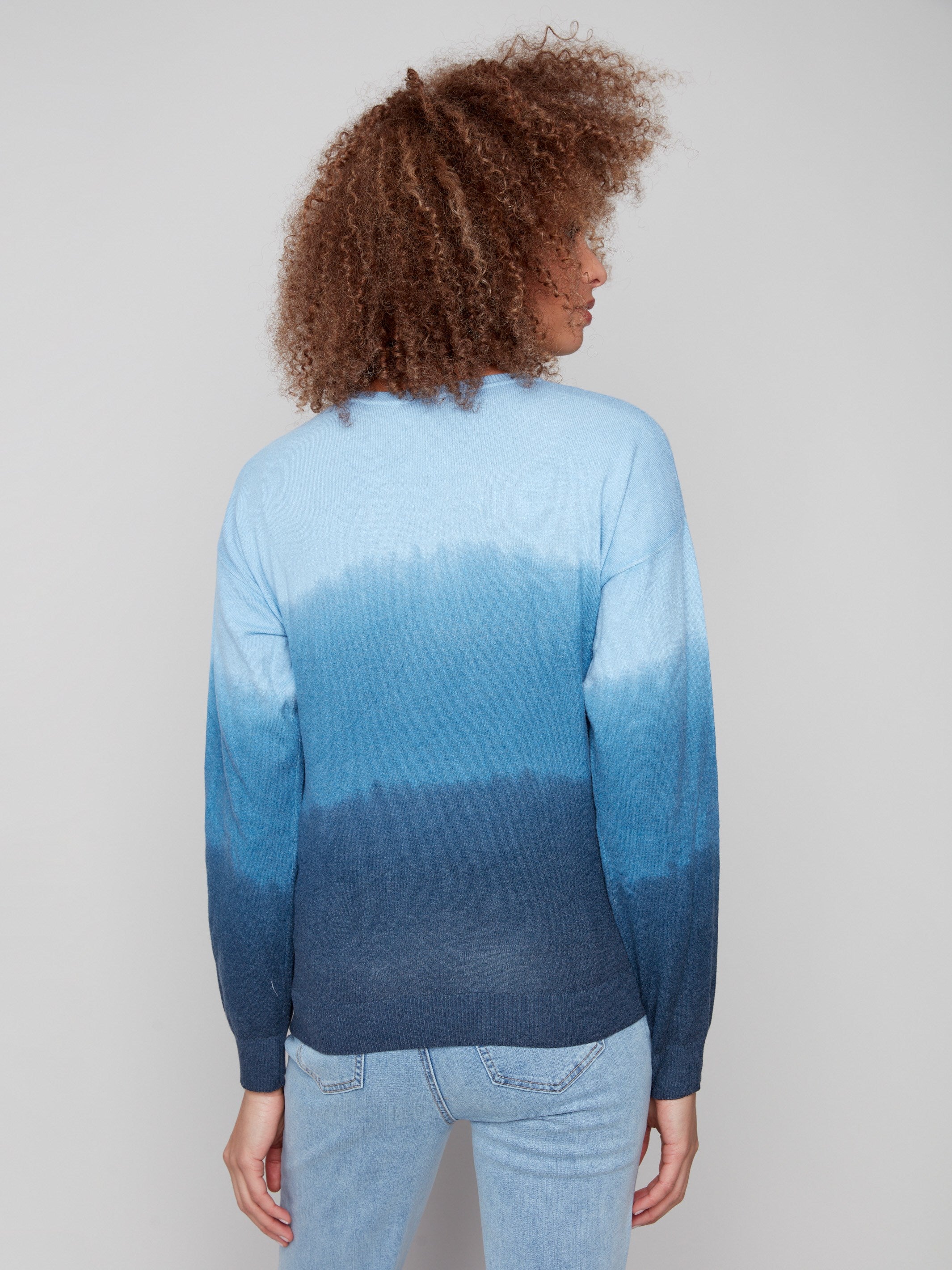 Blue ombre sweater highlighted with knit cuffs, showcasing a seamless blend of colors in an artistic gradient by Charlie B.