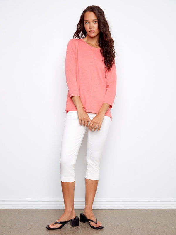 This stylish pink top offers effortless sophistication with its simple yet trendy design. By Charlie B.