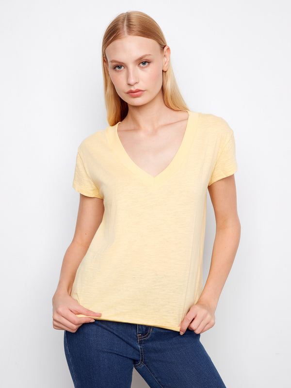 Crafted from lightweight cotton, this yellow V-neck tee ensures breathability and comfort throughout the day. By Charlie B.