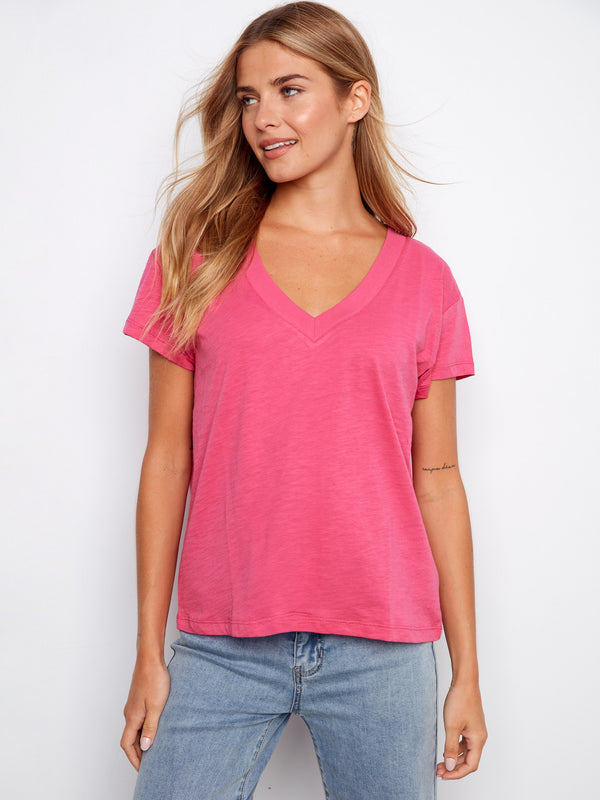 Pink V-neck top featuring a stylish drop shoulder design, ideal for casual outings. Made from lightweight cotton by Charlie B.