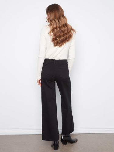 Stylish black wide-leg pants with regular rise, complemented by a white sweater and boots by Charlie B.