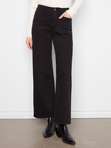 Elegant black twill pants showcasing patch pockets on hips, worn with sleek boots by Charlie B.