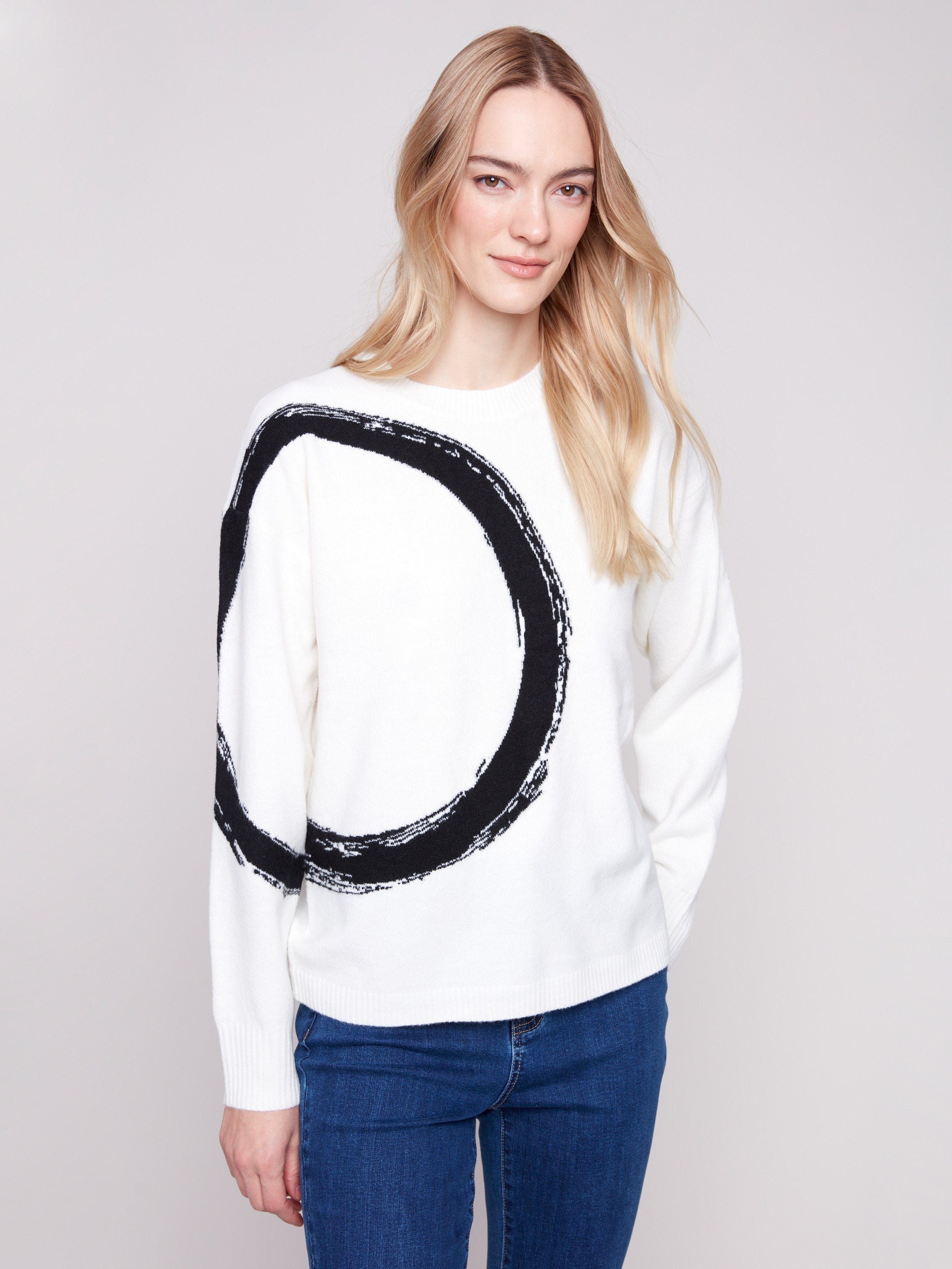Ecru sweater with a bold black abstract circle and ribbed cuffs, offering a stylish touch by Charlie B.