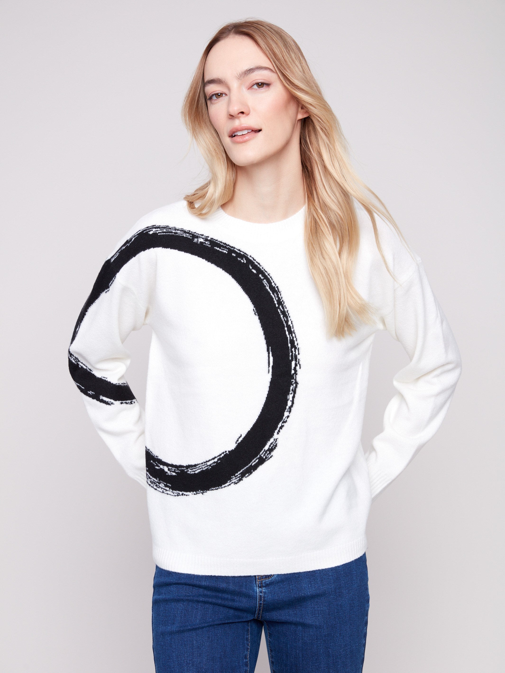 This ecru crew neck sweater with its eye-catching black circle design is perfect for laid-back style by Charlie B.