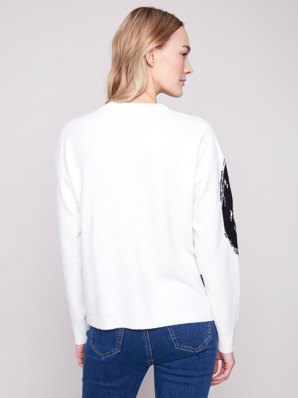Designed with ribbed cuffs, this ecru sweater showcases an artistic black circle motif for modern flair by Charlie B.