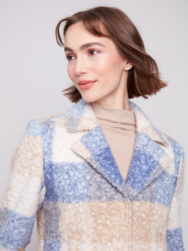 Chic plaid boucle knit coat showcasing welt pockets, offering functionality and style in blue and beige tones by Charlie B.