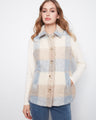 Plaid vest featuring a classic shirt collar, ideal for layering over casual outfits. Styled with a neutral palette. By Charlie B.