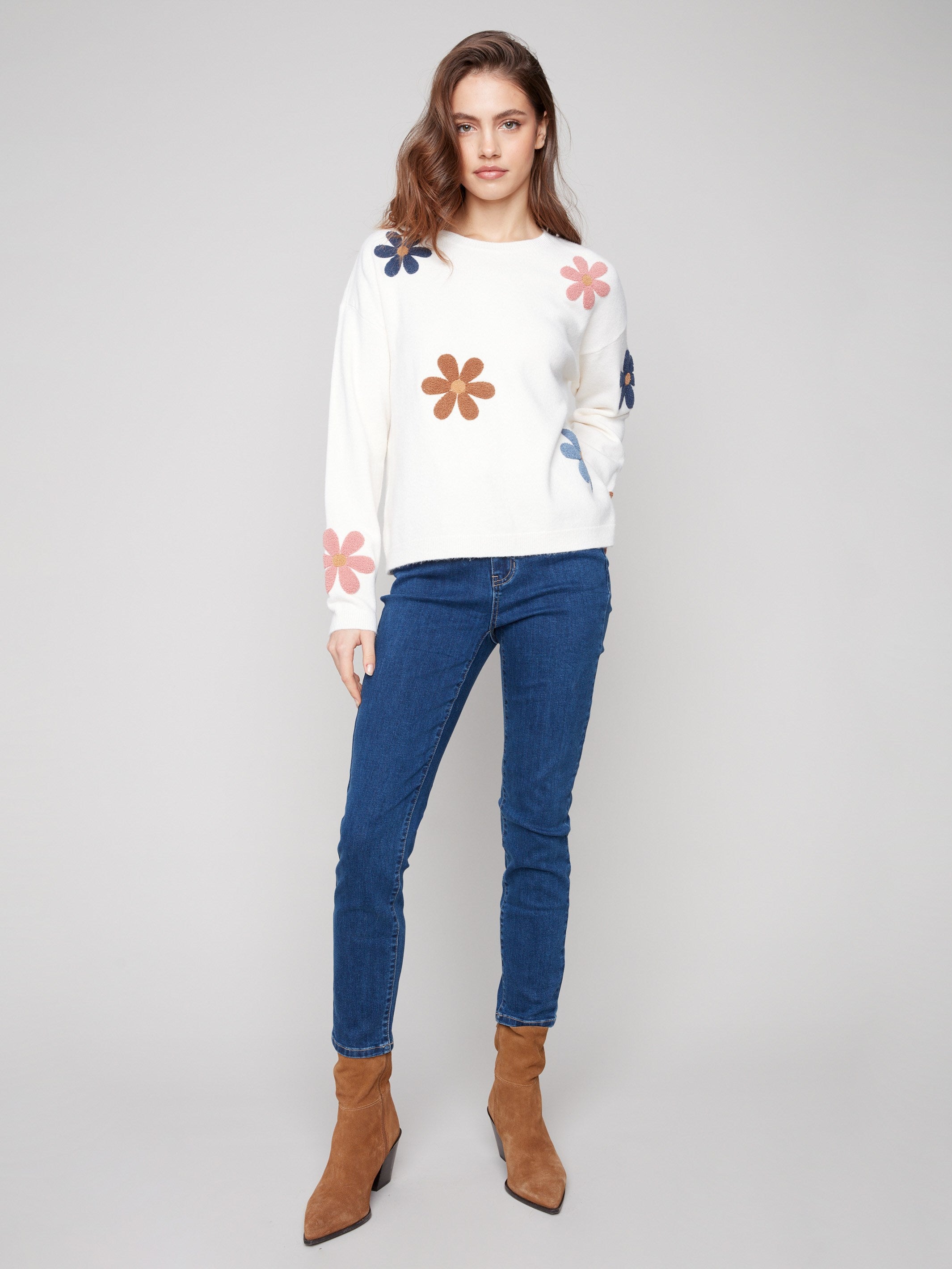 Ecru plush sweater showcasing drop shoulder design, adorned with colorful boucle flowers by Charlie B.