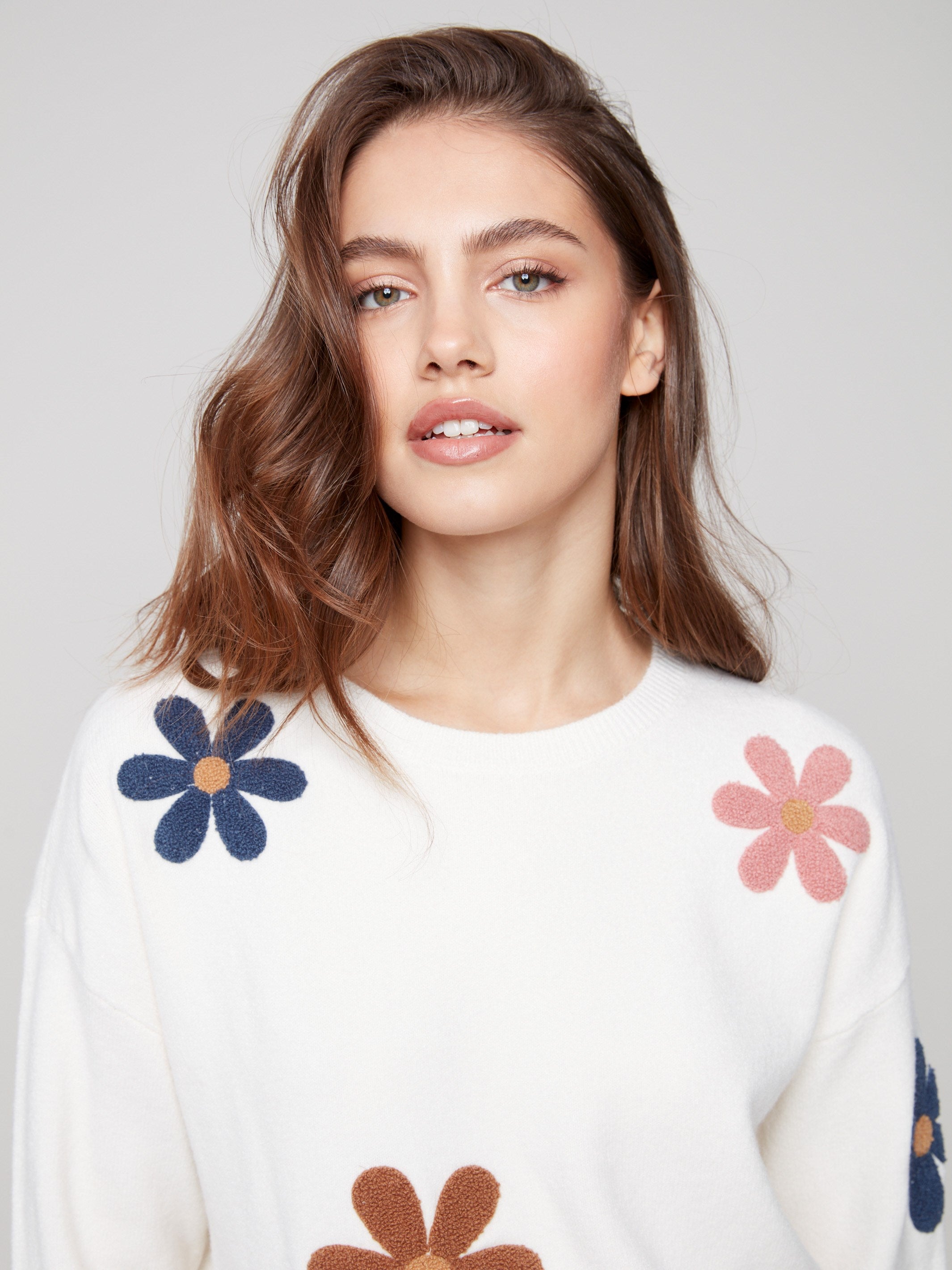 Ecru plush sweater crafted from soft fabric, accented with cheerful boucle flower patterns by Charlie B.