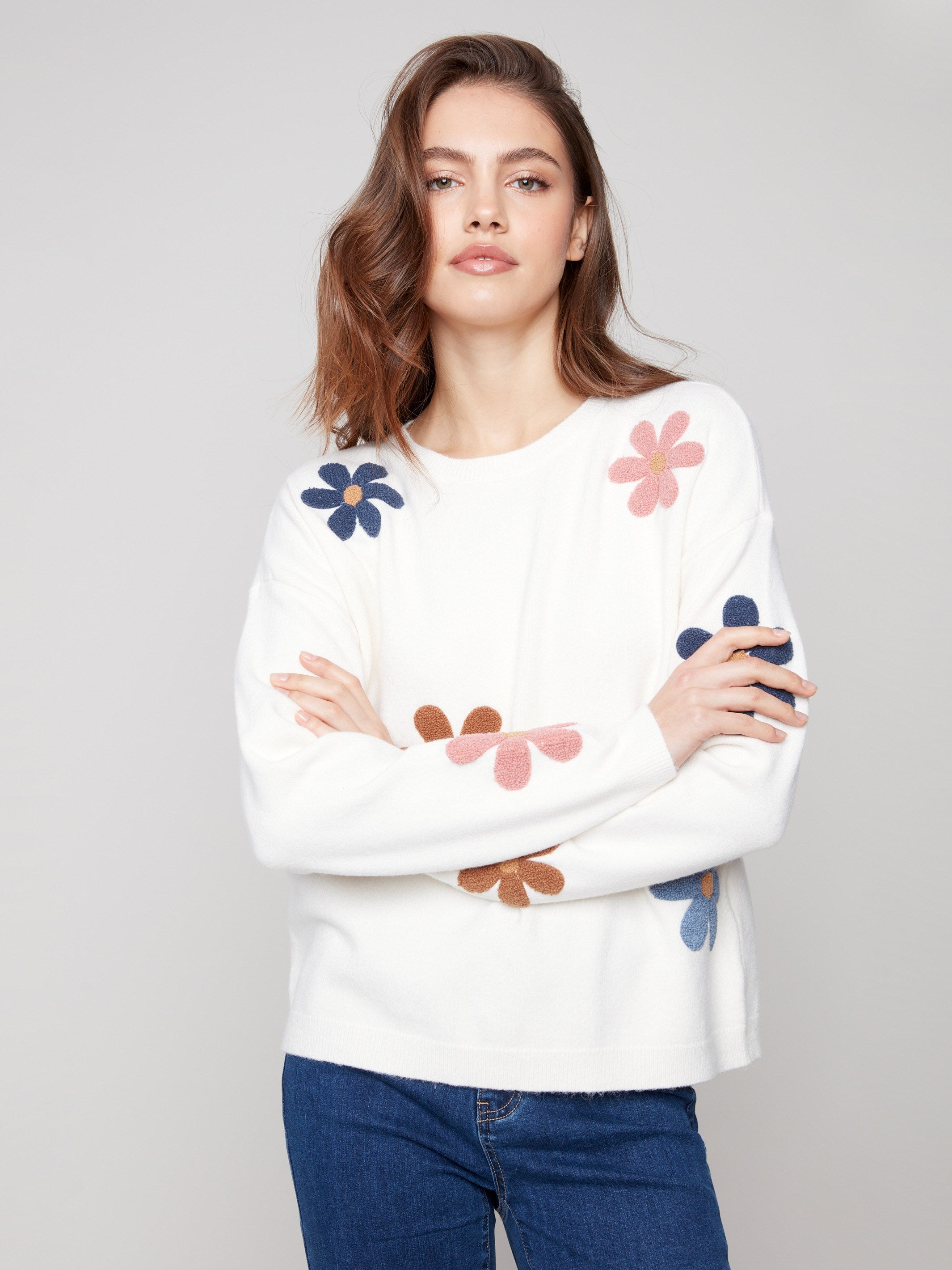 Ecru plush sweater featuring long sleeves and charming colorful boucle flowers for added flair by Charlie B.
