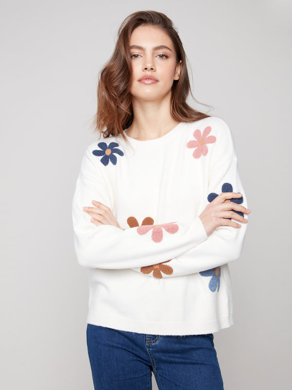 Ecru plush sweater featuring long sleeves and charming colorful boucle flowers for added flair by Charlie B.