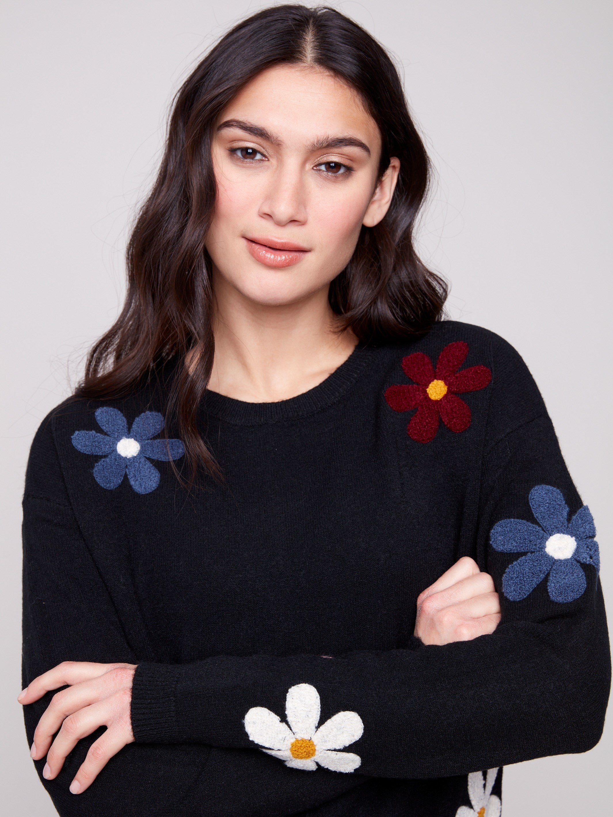 Cozy black sweater in plush fabric, enhanced by colorful boucle flower patterns for a playful look by Charlie B.