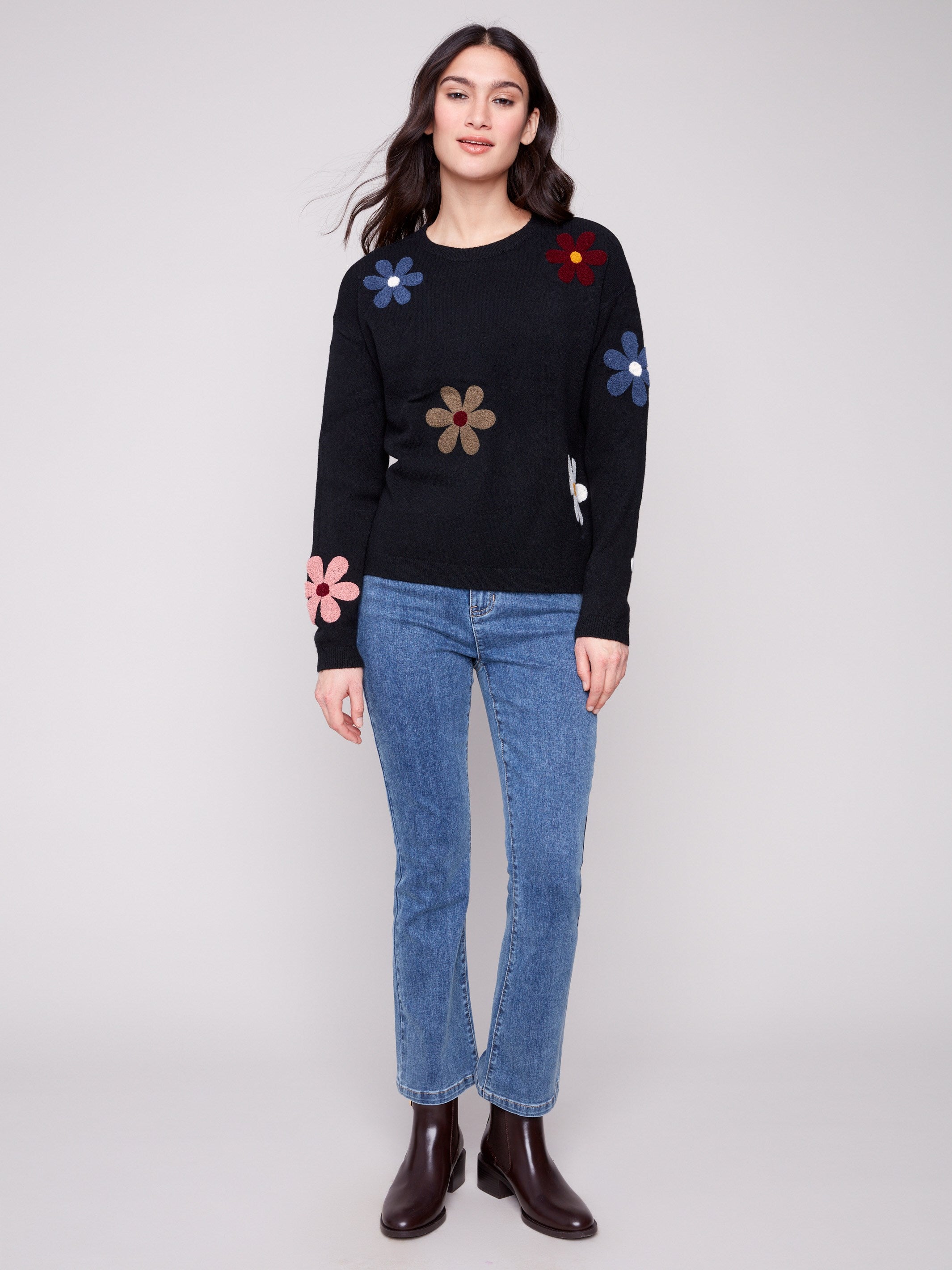 Stylish black sweater featuring drop shoulder design and vibrant boucle flower accents for modern flair by Charlie B.