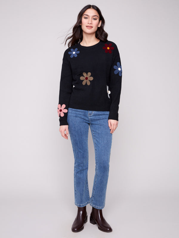 Stylish black sweater featuring drop shoulder design and vibrant boucle flower accents for modern flair by Charlie B.