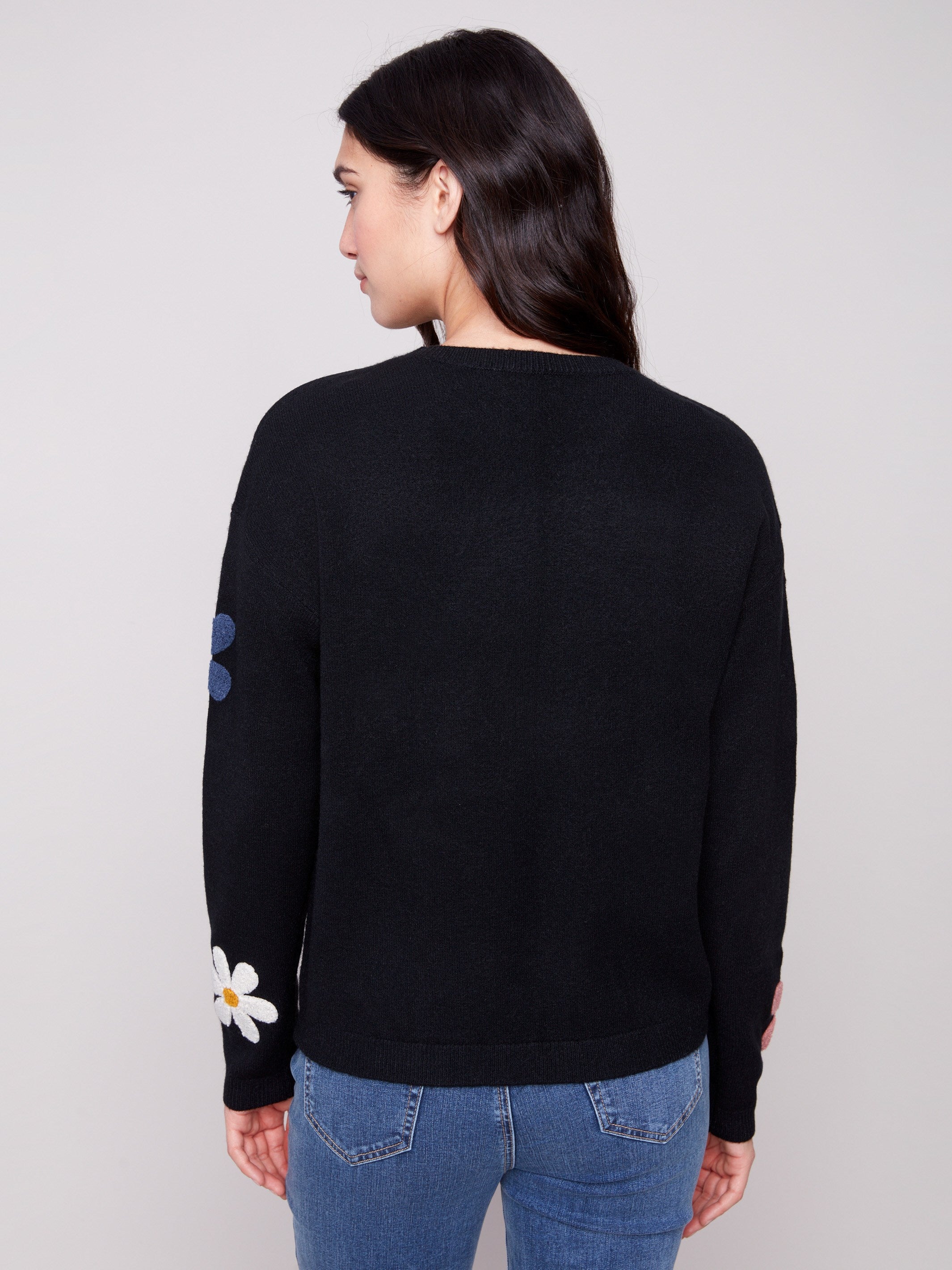 Elegant black sweater showcasing long sleeves with cheerful colorful boucle flower details for added charm by Charlie B.