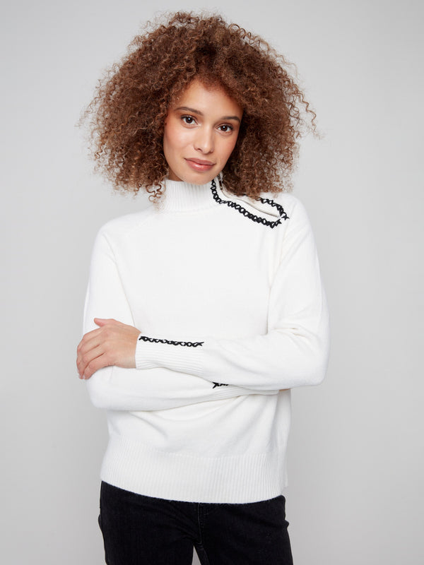 Classic ecru sweater highlighted by detailed stitch accents along the sleeves, offering elegance by Charlie B.