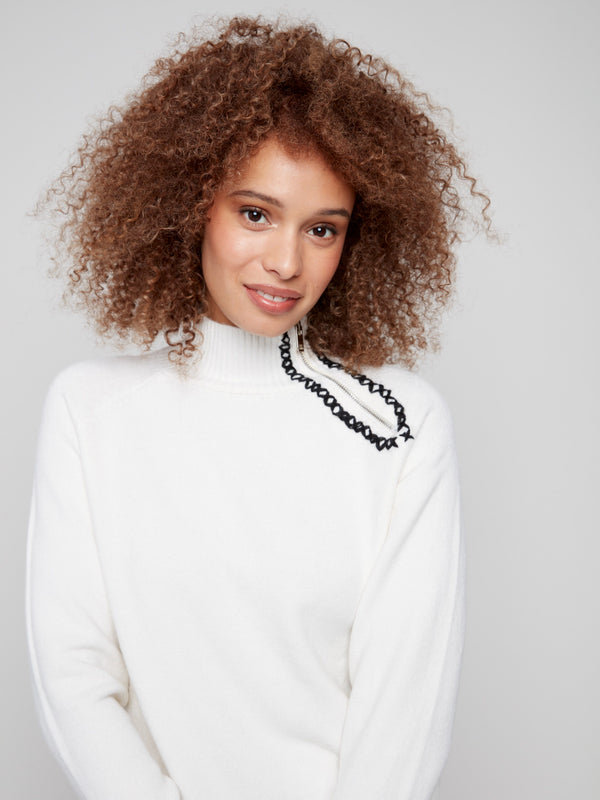 Ecru plush sweater with cozy raglan sleeves and stylish black stitch details for added flair by Charlie B.