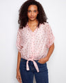 Pink polka dot blouse with a stylish V-neckline, featuring a charming front tie knot detail by Charlie B.
