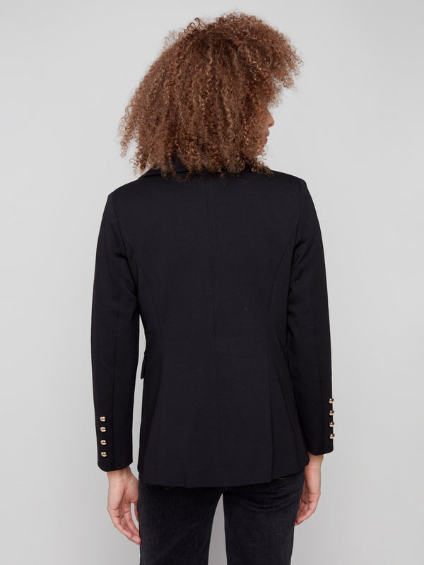 Chic black blazer showcasing exquisite flap pockets, complemented by gleaming gold buttons for added flair by Charlie B.
