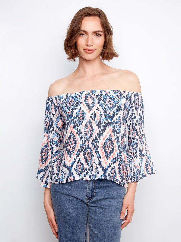 Blouse featuring an off-the-shoulder design with a colorful abstract pattern in lightweight fabric by Charlie B.