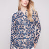 Long sleeve shirt with intricate floral patterns in blue and cream shades, featuring button-down design and foldable cuffs by Charlie B.