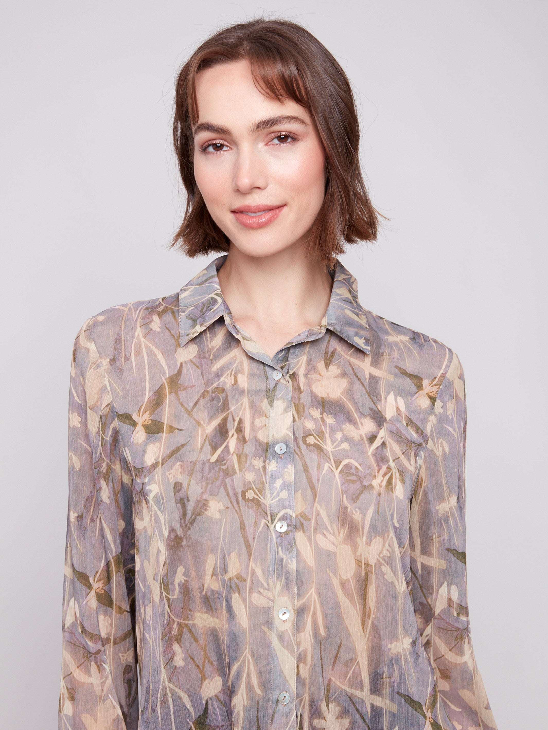 Semi-sheer fabric adds a delicate touch to this floral printed button-up shirt by Charlie B.