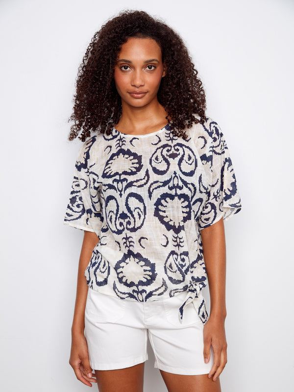 Elegant blouse with a boat neckline, featuring an intricate pattern and comfortable fit. Perfect for casual outings. By Charlie B.