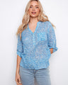 Blue patterned blouse featuring a convenient chest pocket, paired with light jeans for a casual look by Charlie B.