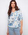 Floral blouse with a chic Henley neckline and soft blue pattern, perfect for casual outings. Crafted with care by Charlie B.