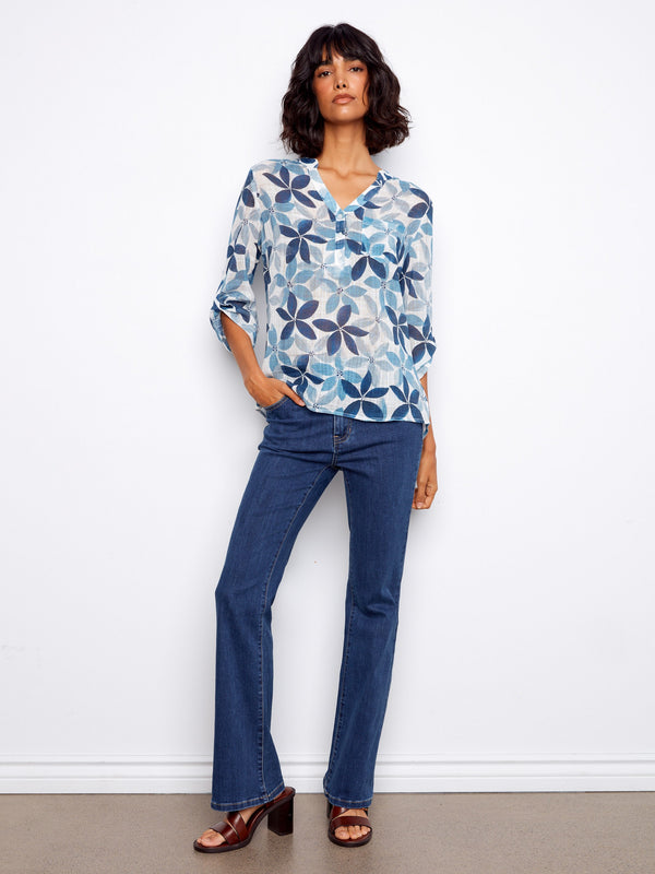 Floral blouse with half-button design, showcasing a Henley neckline and adjustable roll-up sleeves by Charlie B.