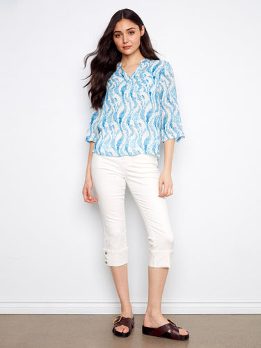 Chic blouse featuring a half-button design in a blue wave pattern, ideal for versatile styling. By Charlie B.