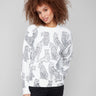 White sweater with a black cheetah print, showcasing a chic drop shoulder design for added style by Charlie B.