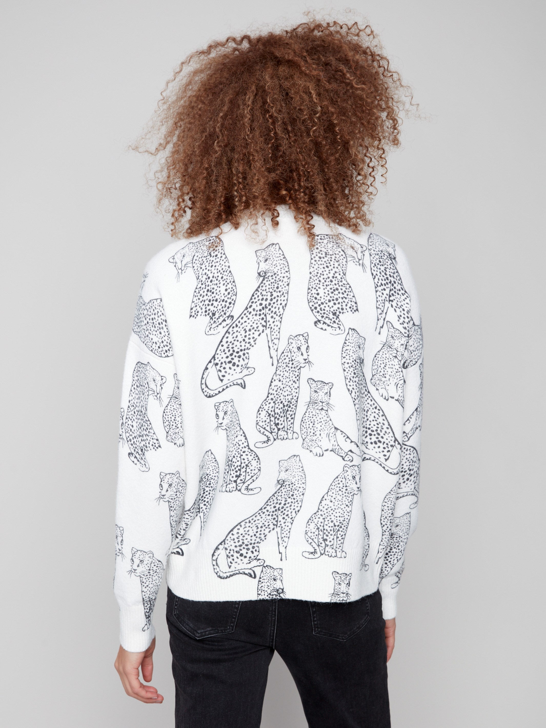 Trendy white sweater displaying a black cheetah pattern, complete with ribbed cuffs and hemline for elegance by Charlie B.