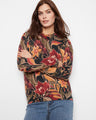 Floral sweater with a crew neckline, showcasing vibrant autumn hues and a comfortable fit. Designed by Charlie B.